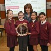 Students in red uniforms stand in Stormont holding awards
