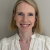 Headshot of a woman smiling with short blonde hair