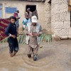 A Concern staff member walks through flood waters in Afghanistan