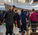 A man carrying water containers in a displacement camp