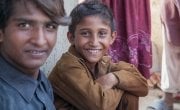 Two young boys sit in a village near Umerkot, Bangladesh. Photo: Black Box Sounds / Concern Worldwide.