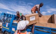 Workers unload kitchen kits from a truck at a distribution in Ndeja, Mozambique, which was hard hit by cyclone Idai in March 2019. Photo: Tommy Trenchard / Concern Worldwide