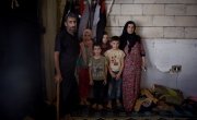 Syrian refugee *Dibeh, 41, and her children *Bilal, 10, *Abdel, 7, and *Omar 8, are pictured in the garage where they are currently living. Photograph by Mary Turner