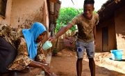 Marriam Jamali received soap as part of of hygiene distribution to help prevent the spread of Covid-19 by Concern in Lilongwe. Her son Bruno helps pour water on her hands while she washes them.