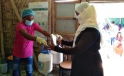 Uzair*, Rohingya Volunteer, helping Concern Worldwide on a double distribution of supplementary food to Rina* to ensure her family have enough to survive. *Name changed to protect the individual’s identity. Photo: AKM Jakaria
