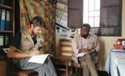 Paolo, Concern WASH advisor, on the left and Frederick Baraka, Concern Emergency WASH PM, on the right, in Munigi. Both of them are interviewing the school director to better understand their needs. Photo: Concern Worldwide