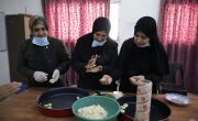 Women prepare 'ghraybeh' with pistachio (shortbread biscuits) at production kitchen training.