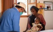 Nutrition Assistant, Roopchand, checks 15 month old girl in Pakistan