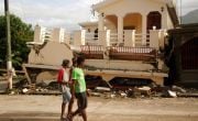 People look at a house that was destroyed by the earthquake in Haiti.