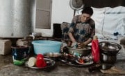 Sheren cleans the dishes after lunch just outside of her tent in Khanke camp. Photo: Concern Worldwide/ George Henton