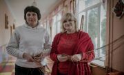 Two women stand in a hallway at a community hub in Ukraine