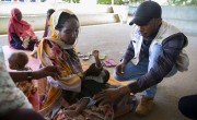 Health and Nutrition Coordinator, Hamdoon Abdala, with Zarina* and baby Yaqub* at Ardamata Health Centre in West Darfur. Photo: Kieran McConville/Concern Worldwide