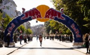  Runners for the Copenhagen Half Marathon run on the course. There are spectators either side and a branded Red Bull arch which participants are running under. 