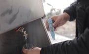 Someone tests the pH level of water from a tap