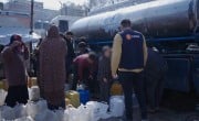 People fill water containers from a truck in Gaza