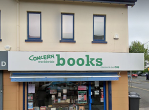 Concern Worldwide Books shop with white signage, large front window, and display of books on a street corner.