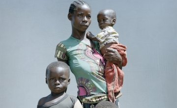 Golden Marlenue, 27 outside her home with her young children. Her two youngest children Naomi, two and Athanase, 12 months, are both malnourished. Photo: Chris de Bode