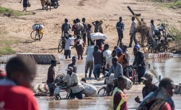People wade across a river in flood near Nhamatanda, Mozambique. Cyclone Idai has disrupted infrastructure across the country, impacting livelihoods and hampering aid efforts. Photo: Tommy Trenchard / Concern Worldwide