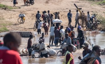 People wade across a river in flood near Nhamatanda, Mozambique. Cyclone Idai has disrupted infrastructure across the country, impacting livelihoods and hampering aid efforts. Photo: Tommy Trenchard / Concern Worldwide