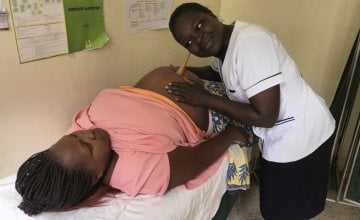Pregnant mum Lucy Syokau (35) is attending an ante-natal check-up at Mukuru Health Centre. Nurse Caroline Nangira checks the position of the baby and prescribes iron and folic acid supplements for the mother. Photographer: Peter Caton