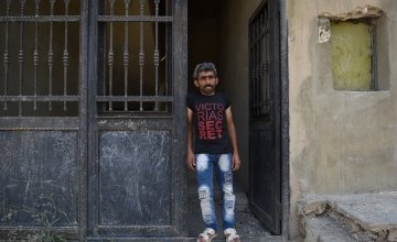 Syrian refugee *Jomaa is pictured in the doorway of the home he shares with his large family and their cousins after being moved by Concern as they were in danger. Photo: Mary Turner