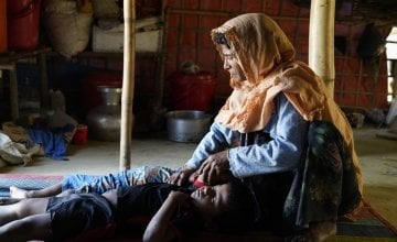 Menara* (40), one of the beneficiary sits beside her sleeping sons at her tent at Jamtoli, Ukhiya. Photo: Abir Abdullah/Concern Worldwide