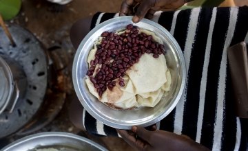 Idil* lives with her three children in a POC in Juba, South Sudan. Here she is cooking Kisro (paper food). Photo: Abbie Trayler-Smith