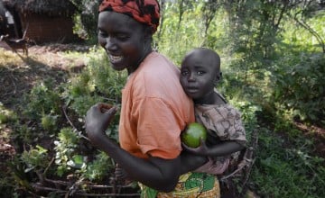 Esperence and her two-year-old daughter Delphine collect ripened avocados from their garden plot in Kirundo, Burundi. Photo: Chris de Bode