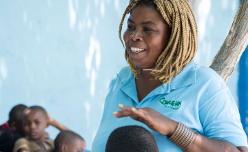 Jasmine listens as Woodson Marcelin tells a story during Children’s Parliament activities in Cité Soleil, Port au Prince. Photo: Kieran McConville/ Concern Worldwide