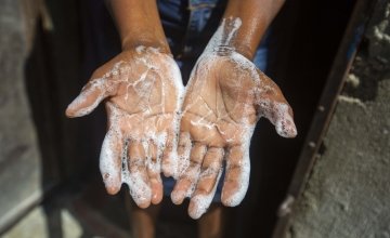 Rosette Mesalien washes her hands with liquid soap in front of their home in Cite Soleil slum a district of Port-au-Prince.