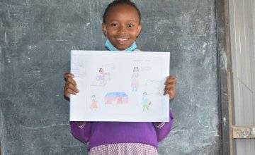 Glory from Kenya pictured with her drawing of what she wants to be when she grows up.