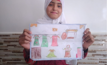 12-year-old Khaled from Syria pictured with her drawing of what she wants to be when she grows up: a tailor.