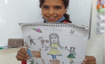 12-year-old Samira from Syria pictured with her drawing of what she wants to be when she grows up.
