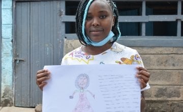 Sheila from Kenya holding her drawing of what she wants to be when she grows up.