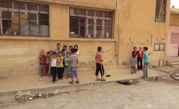 Children playing in their new home which is an abandoned school in Syria. Photographer: Arjan Ottens