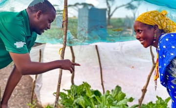 A Concern livelihood officer gives advice to gardener Roge on ways to keep her kale free of disease