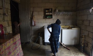 *Sarah cleans the kitchen in her family's home which has been refurbished by Concern in preparation for the winter, in Northern Lebanon Photograph by Mary Turner