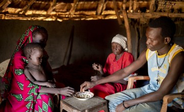 Nyarok* (25) with her daughter Axlam* (2 and a half) pictured in their home with her husband Makur* (24) and his grandmother Kazima* (60). They built and live in small tukel in a rural area of Aweil, South Sudan. Photo: Abbie Trayler-Smith / Concern Worldwide