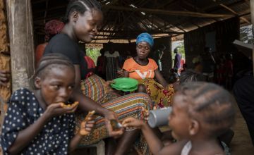 Marie Sawmada eats a meal with two of her children - Love and Baby, provided at the end of a nutrition training session at her local Mothers Group. Photo: Nora Lorek