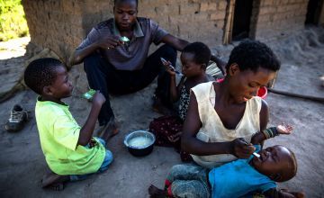 Eriq Kyugu, 28, and his wife Mado, 29, share breakfast with their children, 7 month old baby Bienheureux, 5 year old Bienaime and Esperance, a cousin in the village of Pension, Manono Territory