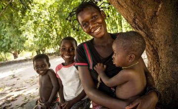 Therese Monga, 24, a beneficiary of Concern Worldwide’s Food for Peace program in Kapotongo village, Manono Territory, is seen with her children Peter (baby), Olie, (7), and Jeanine (3). 