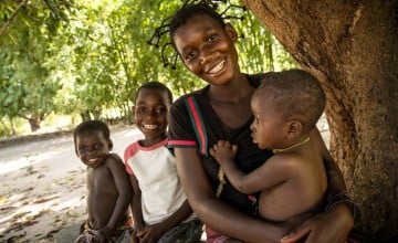 Therese Monga, 24, a beneficiary of Concern Worldwide’s Food for Peace program in Kapotongo village, Manono Territory, is seen with her children Peter (baby), Olie, (7), and Jeanine (3). 