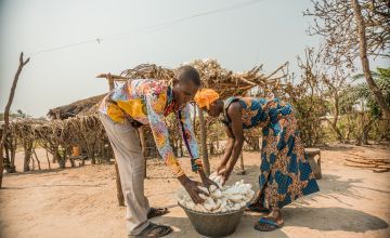 Ivona, (partner of Joseph) is drying the cassava in her plot, an income-generating activity that the couple developed thanks to the support Joseph received from Concern’s Graduation Programme. Photo: Pamela Tulizo/ Panos Pictures