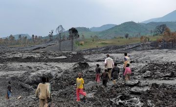 Concern staff and children walking over lava near Munigi and Mujoga, Goma. Photo: Concern Worldwide