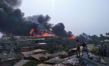 Rohingya refugee children watch as a massive fire rips through Cox's Bazar