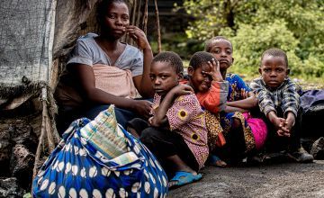éa Busanga and her five children sit in front of the tent they were evacuated to