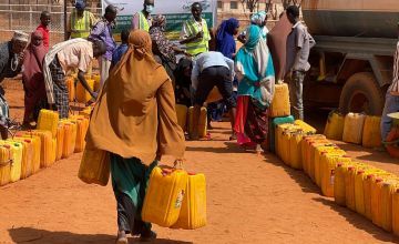A Somali woman walks to Concern's water truck to fill up her containers for her family in Odweyne in the Toghdeer district where water sources have dried up due to drought.