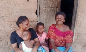 Caustasie (right) and her grandchildren Gloria (middle), five, and Emmanuel, two, sitting on the lap of Concern’s Health and Nutrition Officer Anny Mwamini, Kiambi, DRC. Photo: Concern Worldwide