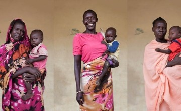 South Sudanese women wearing various shades of pink and holding their infants