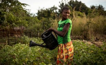 Irene Ngoyi, 29, waters her community’s vegetable garden in the town of Pension, Manono Territory. Photo: Hugh Kinsella Cunningham/Concern Worldwide